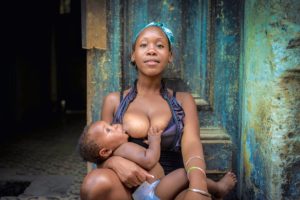 Cuba, Havanna, Woman breastfeeding her baby, looking at camera, Cuba, Havanna, Woman breastfeeding her baby, looking at camera,